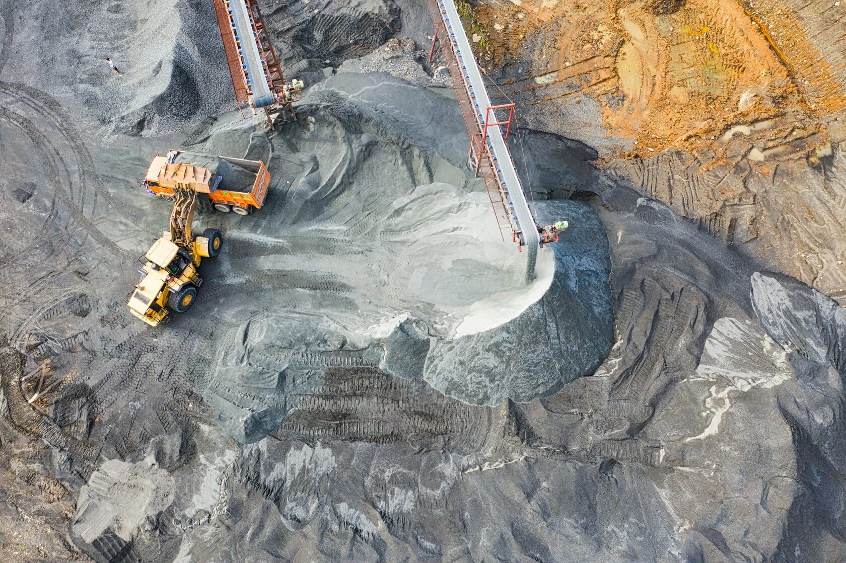 An aerial view of loaders and conveyors working in an aggregate quarry